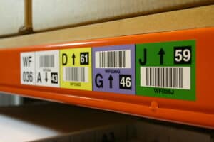 Colour-coded racking labels helping to identify locations in a warehouse.