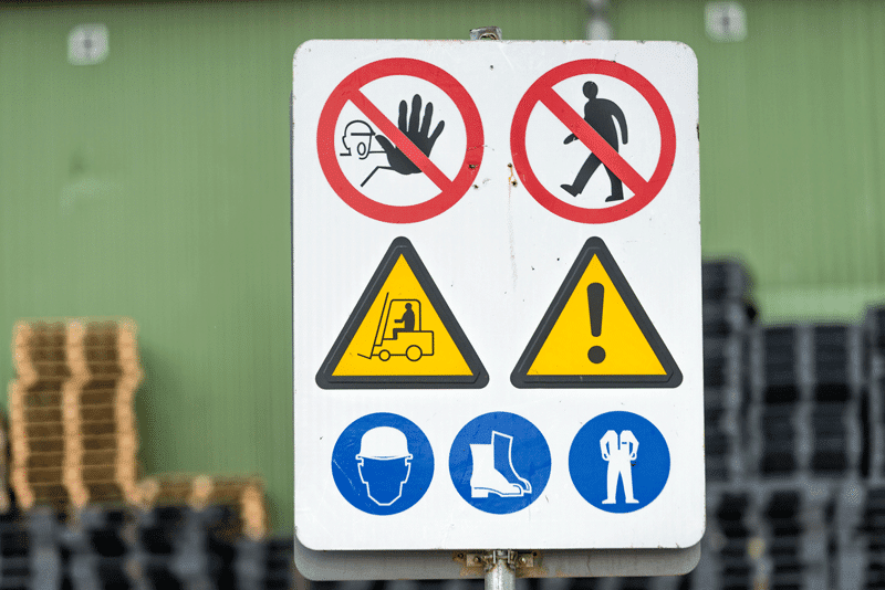 A sign showing multiple safety warnings, including 'no entry', 'forklift traffic' and 'hard hat required'.