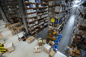 A top-down view of a warehouse interior, with high bay storage packed with goods.