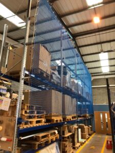 Photo of blue back-of-rack netting in a well-lit warehouse.