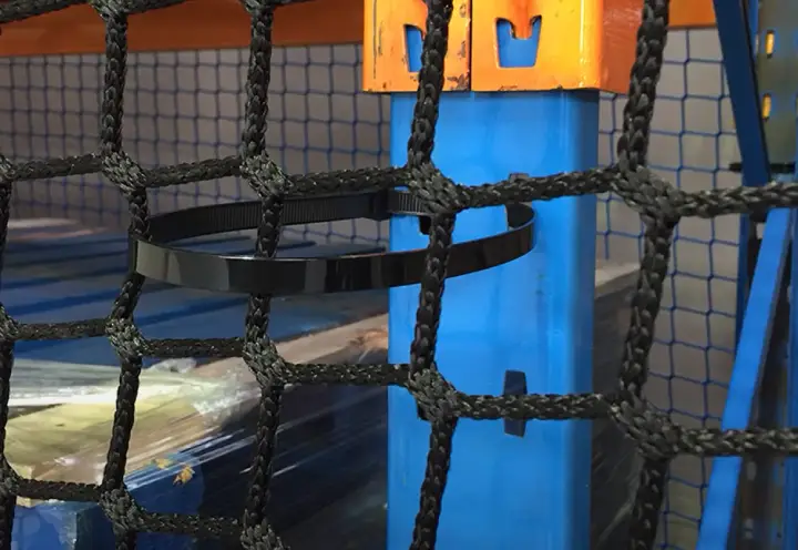 A close up image of a cable tie loosely tied over back-of-rack netting