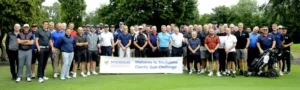 Official image for Stockdales Golf Day showing players on the golf course, with a Stockdales event banner in front of the group.